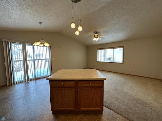 kitchen featuring ceiling fan with notable chandelier, a textured ceiling, lofted ceiling, a kitchen island, and hanging light fixtures