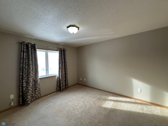 carpeted empty room with a textured ceiling