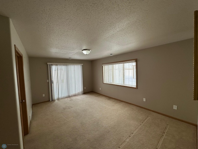 carpeted spare room featuring a textured ceiling