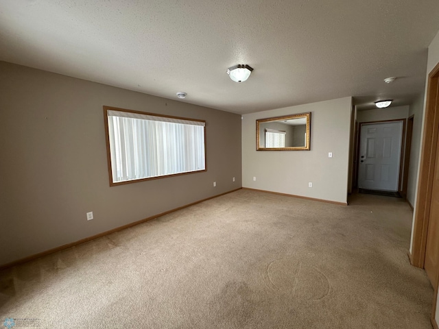 empty room featuring carpet and a textured ceiling