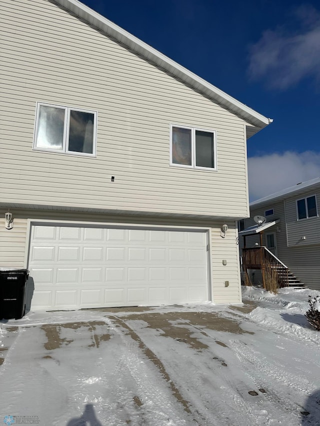 snow covered property featuring a garage