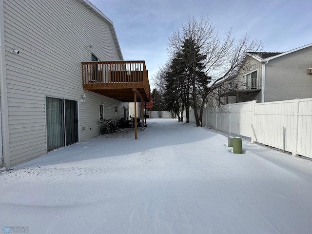 snowy yard featuring a wooden deck