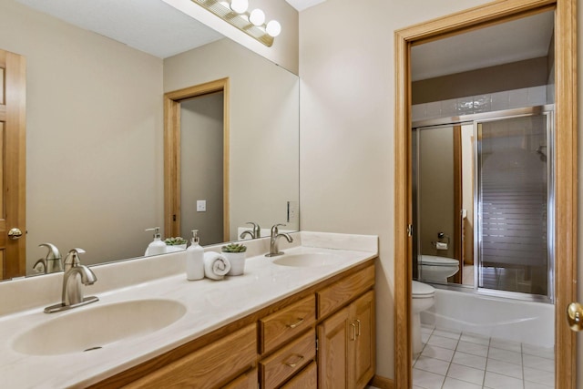 full bathroom featuring vanity, toilet, combined bath / shower with glass door, and tile patterned floors