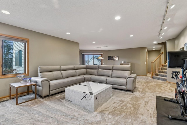 living room featuring rail lighting, light carpet, and a textured ceiling