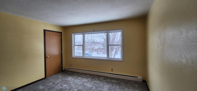 empty room with a textured ceiling, carpet floors, and a baseboard heating unit