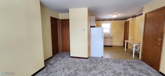 unfurnished bedroom with light carpet and white refrigerator