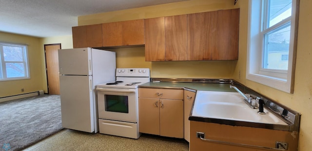 kitchen featuring a healthy amount of sunlight, white appliances, sink, and a baseboard heating unit