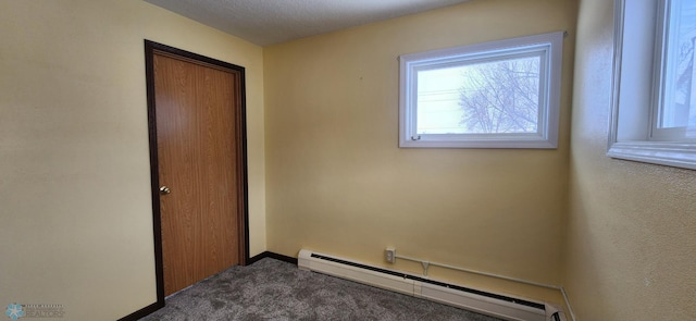 spare room featuring carpet flooring and baseboard heating