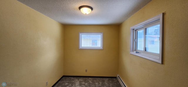 carpeted spare room with a textured ceiling and a baseboard heating unit