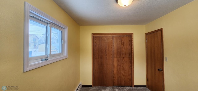 hallway with plenty of natural light, carpet, and a textured ceiling