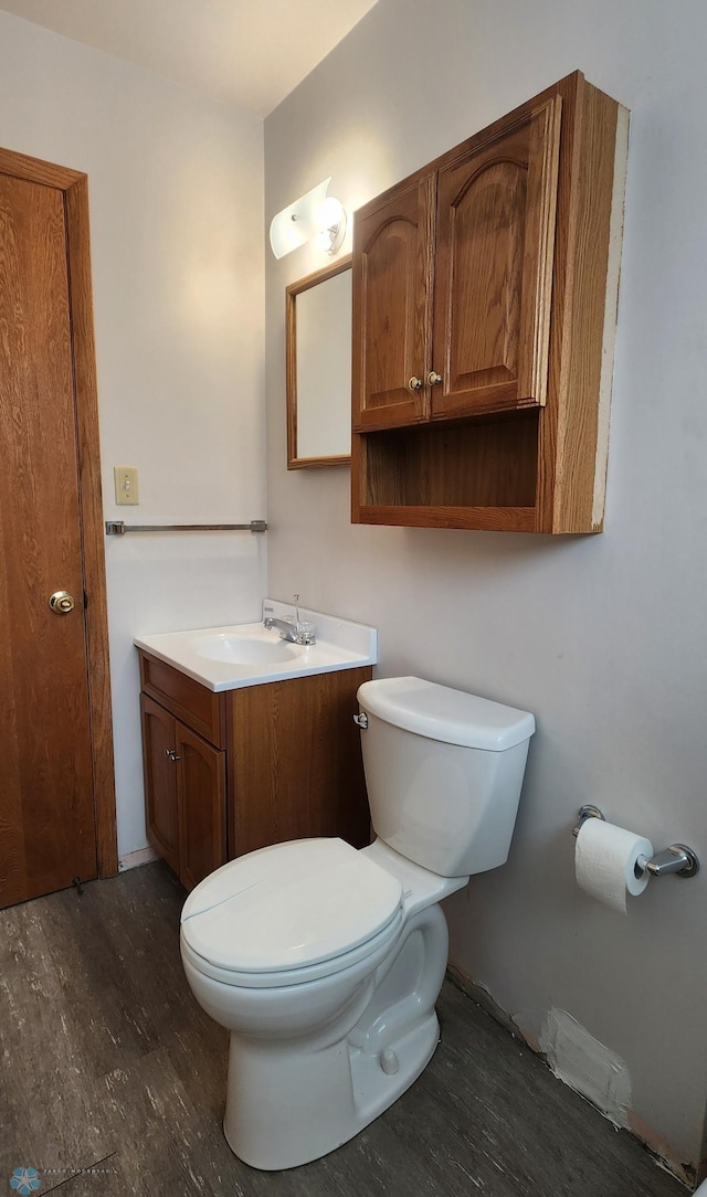 bathroom with hardwood / wood-style flooring, vanity, and toilet