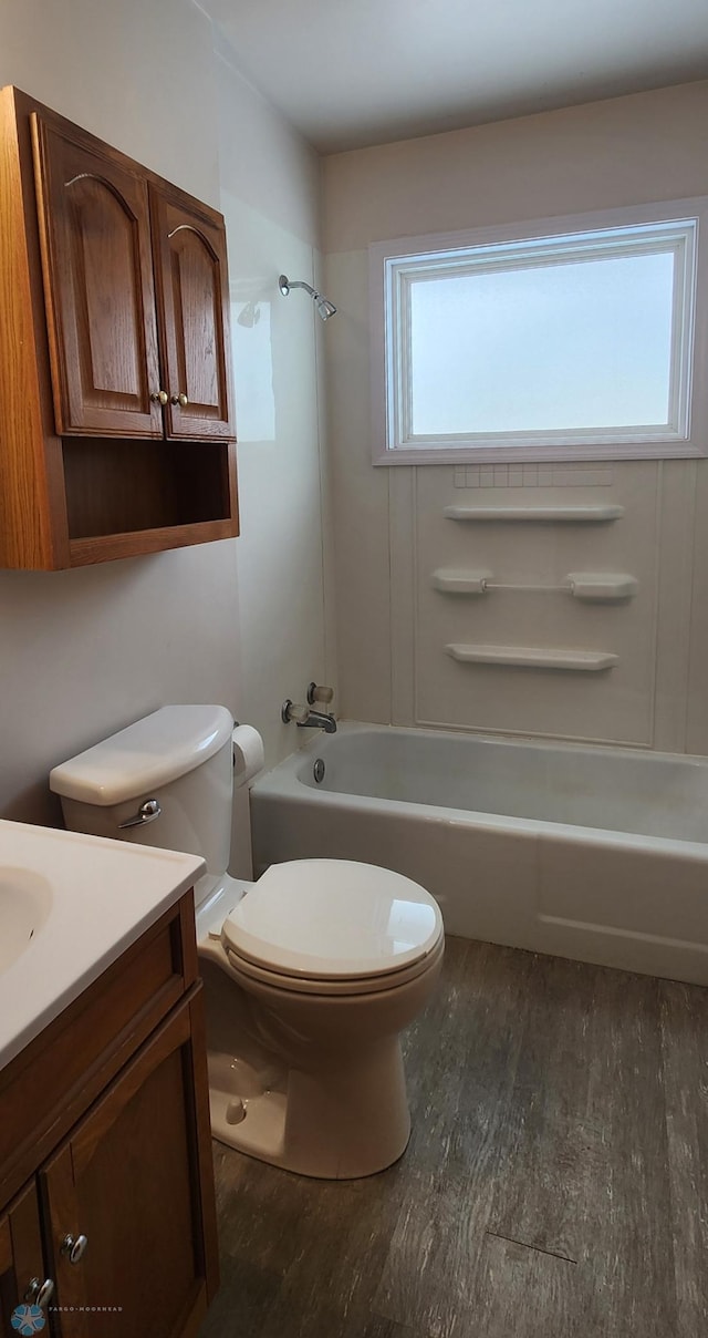 full bathroom featuring hardwood / wood-style floors, vanity, toilet, and bathing tub / shower combination