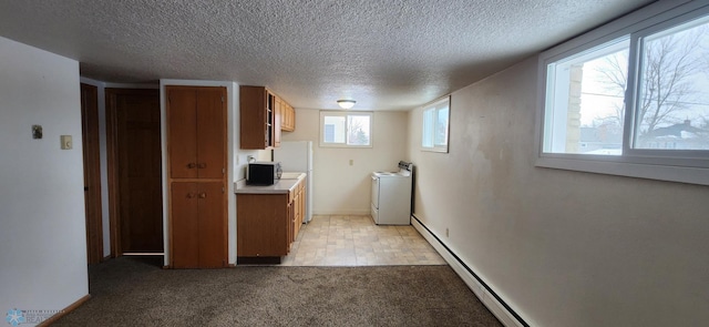 kitchen featuring light colored carpet, a textured ceiling, washer / clothes dryer, and a baseboard heating unit