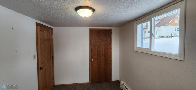 hallway with carpet, a textured ceiling, and a baseboard heating unit