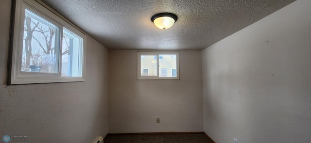 unfurnished room featuring carpet flooring and a textured ceiling