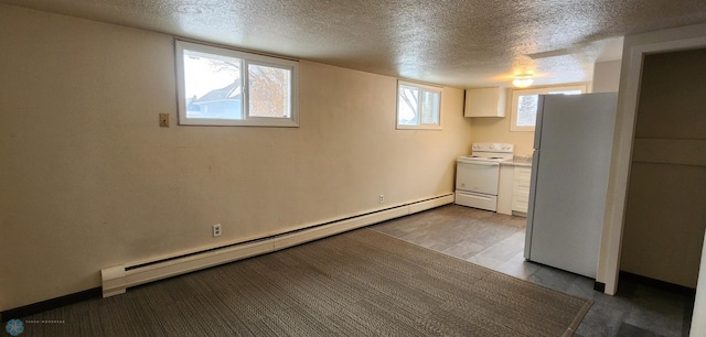 basement with white fridge, a textured ceiling, and a baseboard heating unit