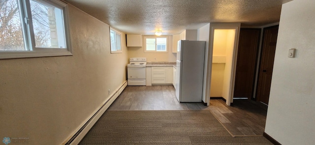 kitchen featuring plenty of natural light, dark hardwood / wood-style flooring, and white appliances