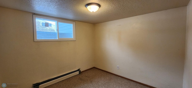 carpeted empty room with a textured ceiling and a baseboard heating unit