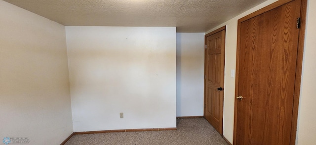 carpeted empty room featuring a textured ceiling