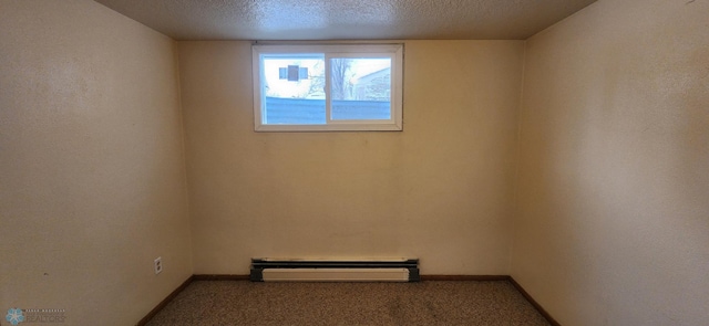 spare room featuring carpet, a baseboard radiator, and a textured ceiling