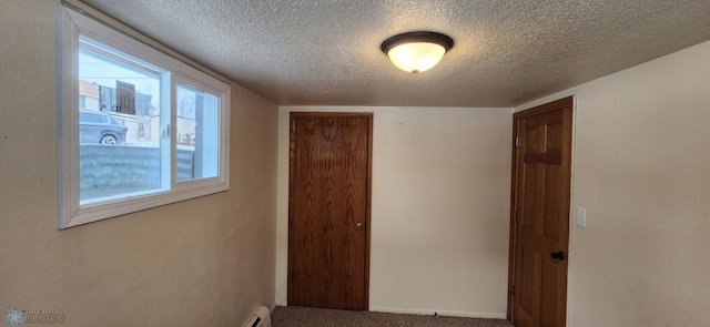 corridor with carpet, a healthy amount of sunlight, and a textured ceiling