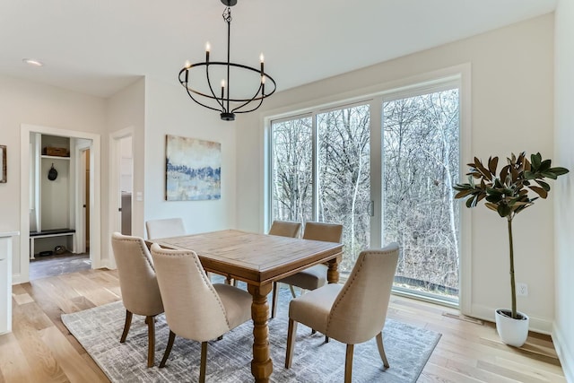 dining area with light hardwood / wood-style flooring and a chandelier