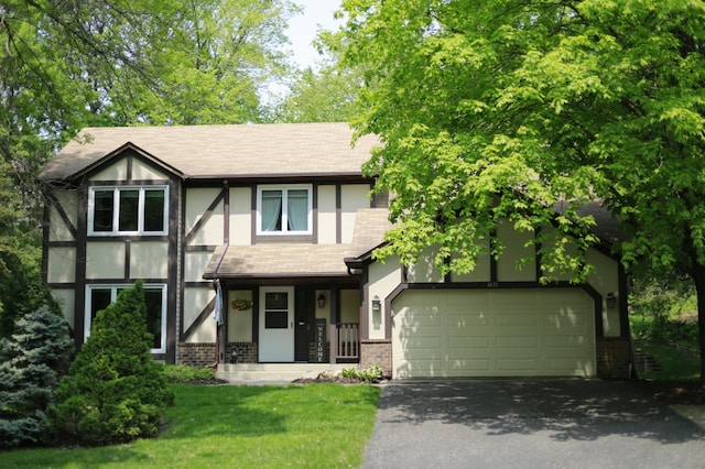 tudor home with a garage and a porch