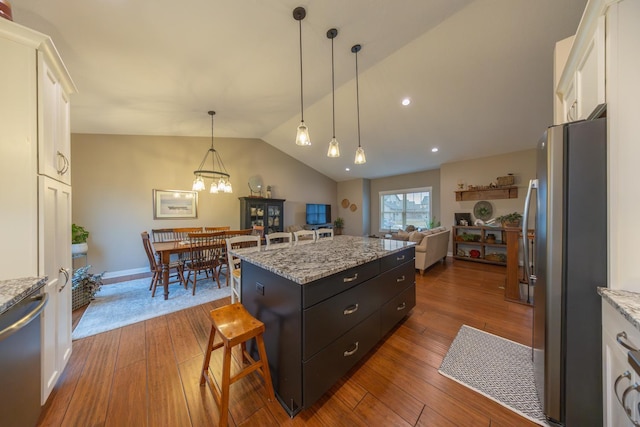 kitchen featuring a center island, dark wood-type flooring, hanging light fixtures, appliances with stainless steel finishes, and white cabinetry