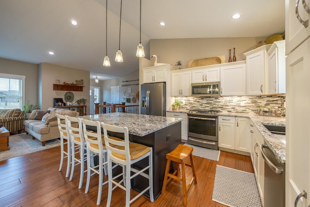 kitchen with backsplash, a center island, white cabinetry, and stainless steel appliances