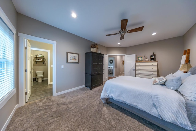 carpeted bedroom featuring multiple windows, ceiling fan, and ensuite bath