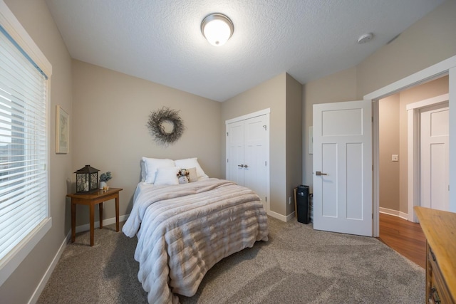 carpeted bedroom with a textured ceiling and a closet