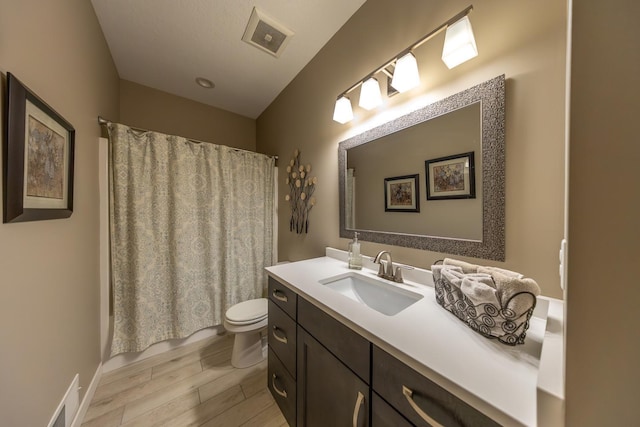 full bathroom featuring hardwood / wood-style flooring, vanity, toilet, and shower / bathtub combination with curtain