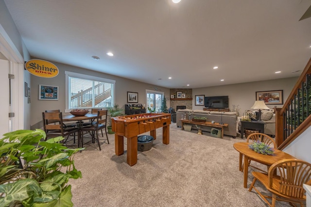 rec room featuring light carpet and a fireplace