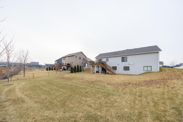 rear view of house featuring a deck and a yard