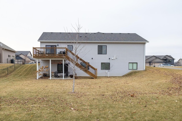 rear view of property featuring a yard, a patio, and a wooden deck