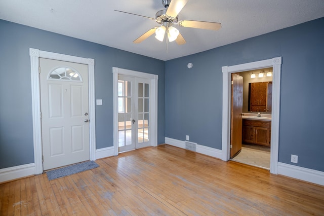 entrance foyer with ceiling fan, french doors, light hardwood / wood-style floors, and sink