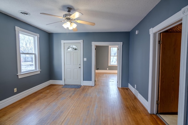 foyer entrance featuring light wood-type flooring, plenty of natural light, and ceiling fan