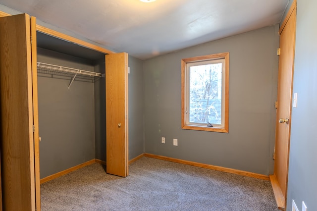 unfurnished bedroom featuring light carpet and a closet