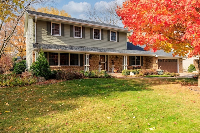 front of property featuring a front yard, a garage, and a porch