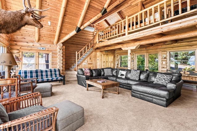 carpeted living room with beam ceiling, high vaulted ceiling, rustic walls, and wooden ceiling