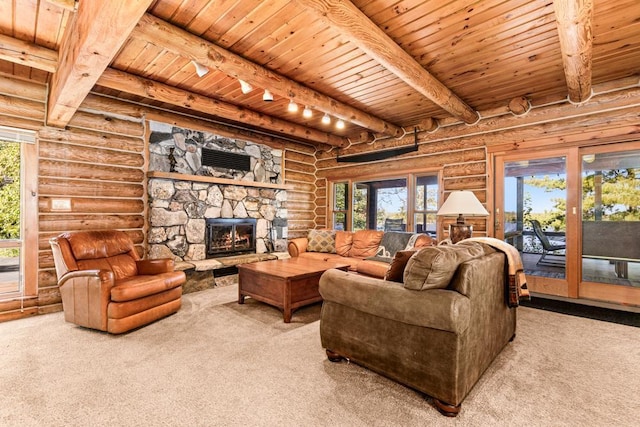 living room featuring carpet, rail lighting, log walls, beamed ceiling, and a fireplace