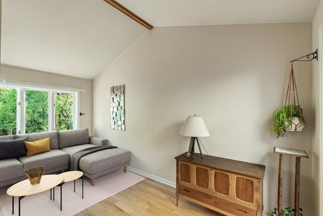 living room with lofted ceiling with beams and light hardwood / wood-style floors