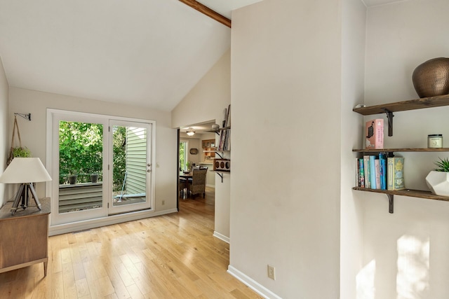 foyer entrance featuring ceiling fan, light hardwood / wood-style floors, and vaulted ceiling