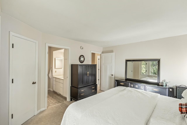 bedroom featuring ensuite bathroom and light colored carpet