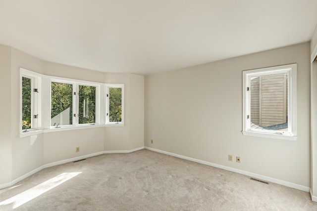 unfurnished room featuring light colored carpet