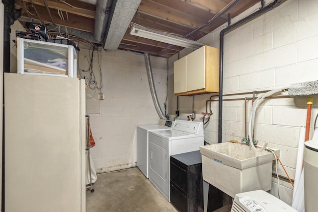 laundry room featuring washer and dryer, cabinets, and sink