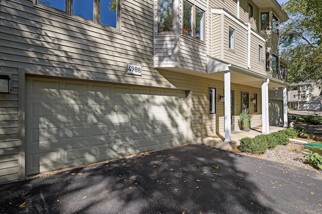 view of property exterior with covered porch and a garage