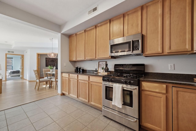 kitchen featuring hanging light fixtures, light tile patterned floors, and stainless steel appliances