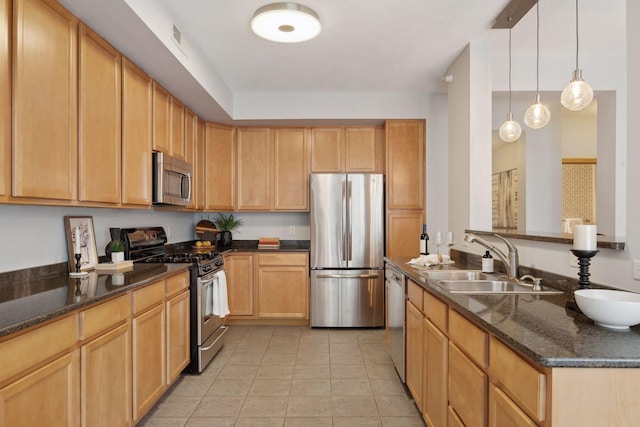 kitchen featuring light tile patterned floors, stainless steel appliances, dark stone counters, hanging light fixtures, and sink