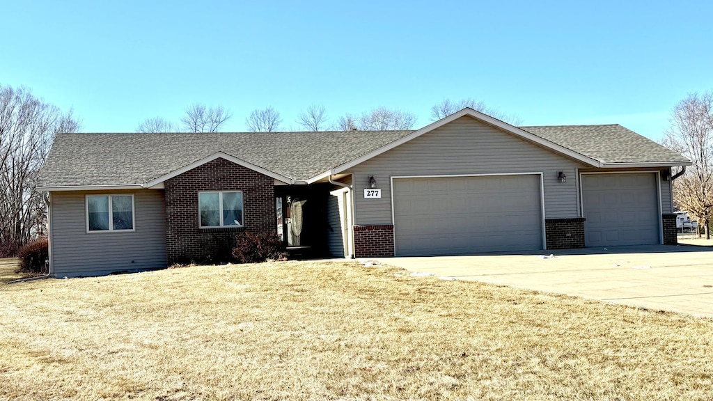 ranch-style house with a garage and a front lawn